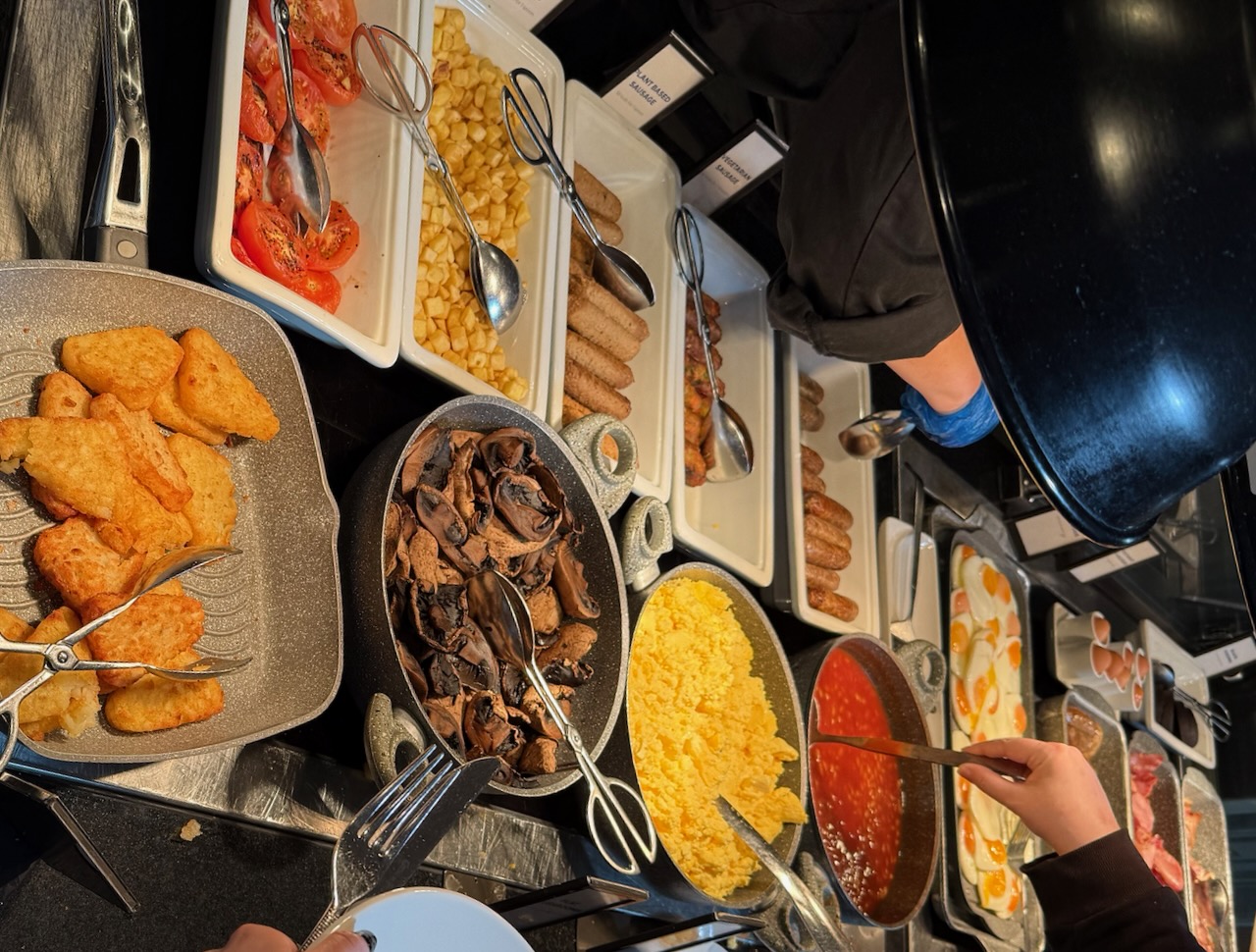 An assortment of hot food at a well-stocked hotel breakfast buffet